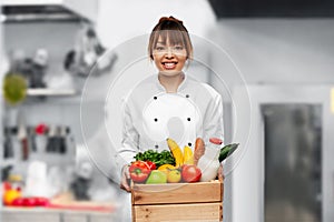 happy female chef with food in box on kitchen