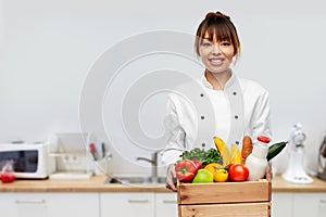 happy female chef with food in box on kitchen