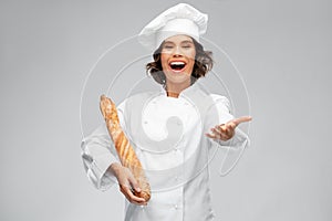 Happy female chef with french bread or baguette