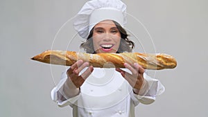 Happy female chef with french bread or baguette