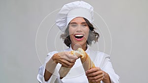 Happy female chef with french bread or baguette