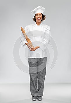 Happy female chef with french bread or baguette