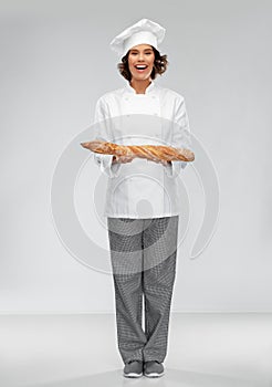 Happy female chef with french bread or baguette