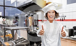 Happy female chef showing thumbs up at kebab shop