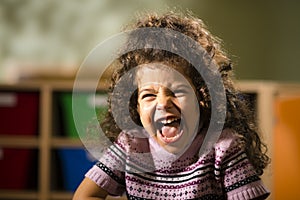 Happy female child smiling for joy in kindergarten