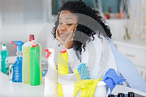 happy female cleaner looking at cleaning products