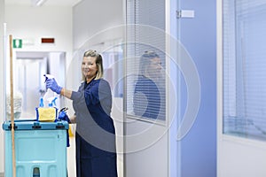 Happy female cleaner smiling in office photo