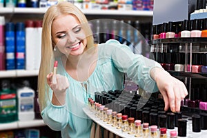 Happy female customer buying red lipstick