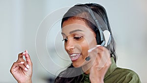 Happy female customer service agent smiling while working in a call centre and talking to a client with a headset. A