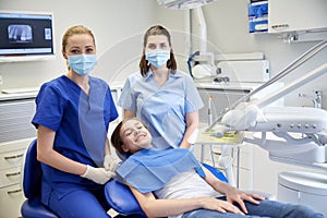 Happy female dentist with patient girl at clinic