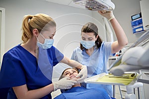 Happy female dentist with patient girl at clinic