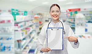 Happy female doctor with clipboard at pharmacy