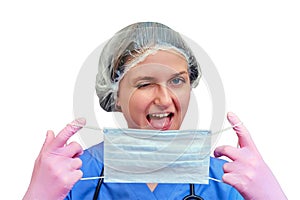 A happy female doctor holds a medical mask and winks, copy space fo