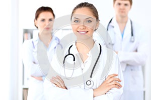 Happy female doctor with medical staff at the hospital.