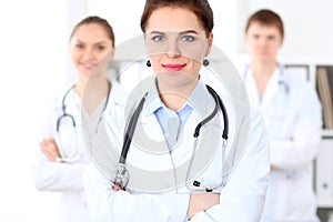 Happy female doctor with medical staff at the hospital.