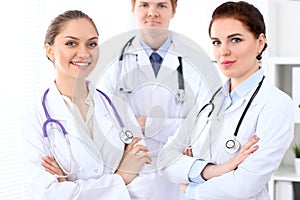 Happy female doctor with medical staff at the hospital.