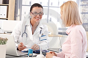 Happy female doctor at office with patient