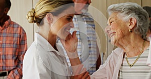 Happy female doctor and senior woman looking face to face 4k