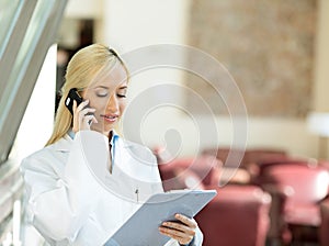 Happy female doctor talking to a patient on a phone