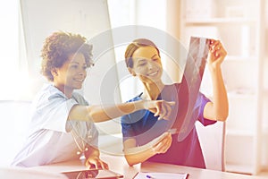 Happy female doctors with x-ray image at hospital