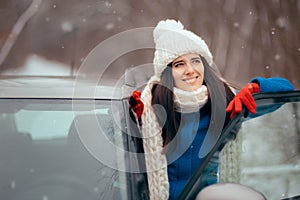 Happy Female Driver Standing By Her Car Admiring the Snow