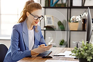 Happy female entrepreneur dial the number on smartphone