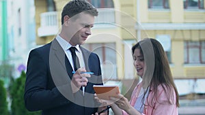 Happy female fan asking for autograph from handsome famous man suit, celebrity