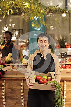 Happy female farmer with fresh organic produce box