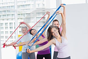 Happy female friends exercising with resistance bands