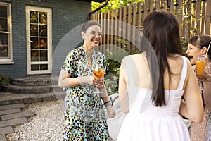 Happy female friends spending time together, young woman drinking Aperol spritz cocktail