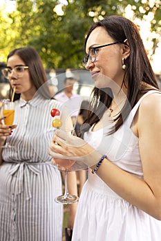Happy female friends spending time together, young woman drinking Aperol spritz cocktail
