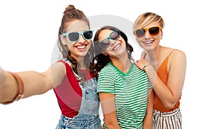 Happy female friends in sunglasses taking selfie