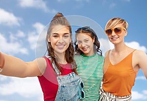 Happy female friends in sunglasses taking selfie