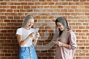 Happy female friends using smartphones