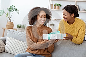 Happy female give gift for mixed race lady