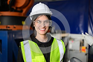 Happy female maintenance engineer worker working at industrial factory