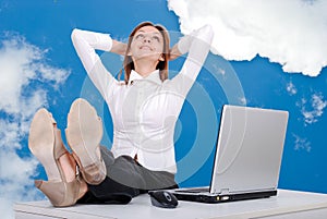 Happy female model with legs on desk