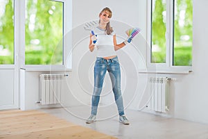 Happy female painter holding paintroller and color palette photo