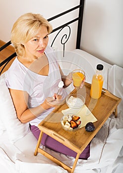 Happy female pensioner having breakfast