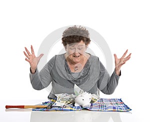 Happy female pensioner after smashing her piggy box. Money concept senior people.