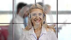 Happy female pharmacy customer support operator in headset.