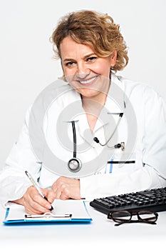 Happy female physician at work desk