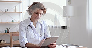 Happy female professional doctor using digital tablet at work