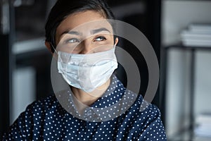 Happy female in protective mask look in distance dreaming