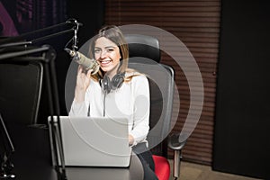 Happy female radio broadcaster hosting a live show