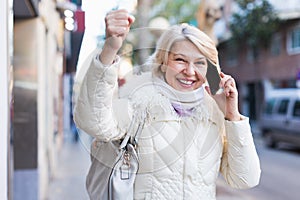 Happy female raise hand up and talking on phone