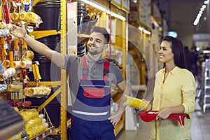 Happy female shopper in building materials store chooses tools for home make repairs.