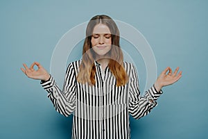 Happy female smiling with eyes closed holding hands in yoga zen gesture