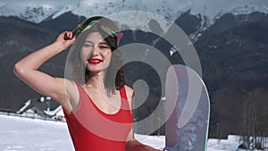 Happy female snowboarder posing for camera