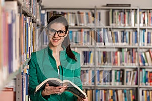 Happy Female Student With Book In Library